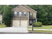 Charming brick two-story home with a two-car garage and well-manicured front lawn at 749 Rolling Downs Dr, Loganville, GA 30052