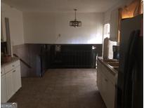 Bright kitchen with white cabinets, tile floor, and a view of the lower level at 2017 Pine Cone Sw Dr, Atlanta, GA 30331