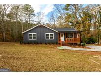 Charming gray home featuring a cozy front porch, manicured landscaping, and welcoming curb appeal at 79 Turner Dr, Mcdonough, GA 30252