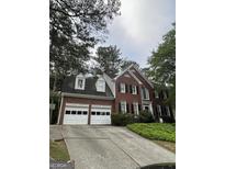 Beautiful two-story brick home with white garage doors and lush landscaping at 171 Galesburg Dr, Lawrenceville, GA 30044
