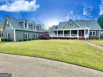 Sprawling home with green lawn, mature trees and long porch at 1040 Rock Creek Rd, Social Circle, GA 30025
