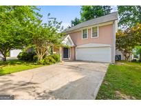 Charming two-story home with a spacious driveway and attached garage, surrounded by lush landscaping at 402 Sherrels Frd, Peachtree City, GA 30269