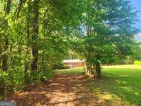 Charming single-story home nestled among the trees, with a beautiful green lawn at 309 Cornish Mountain Rd, Covington, GA 30014