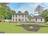 Stunning white-brick two-story home featuring a well-manicured lawn and tasteful landscaping at 400 Walnut Grove Rd, Peachtree City, GA 30269