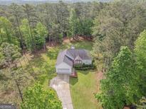 An aerial view of a charming home nestled within a lush, mature tree canopy providing an abundance of shade at 2180 Briarwood Ct, Villa Rica, GA 30180