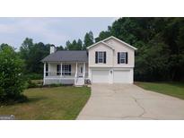 Charming two-story home with a two car garage, covered porch, and well-maintained lawn at 2477 Briar Valley Way, Dacula, GA 30019