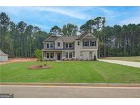 Inviting two-story home featuring a well-manicured lawn, neutral color scheme, and complementary landscaping at 100 Bre Dr, Fayetteville, GA 30214