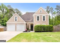 Charming two-story home featuring a well-manicured lawn and a two-car garage at 150 Rockspray Rdg, Peachtree City, GA 30269
