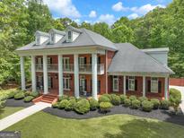 Stunning two-story brick home featuring a columned front porch and beautifully landscaped front yard at 602 Embassy Ct, Peachtree City, GA 30269