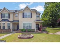 Inviting townhome with well-manicured lawn, tidy shrubs, and a cozy front entrance at 7293 Bridlewood Ct, Jonesboro, GA 30236