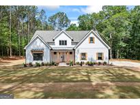 Stunning new construction features a modern farmhouse exterior with stylish wood-look shutters and a meticulously manicured front yard at 4731 H D Atha Rd, Covington, GA 30014