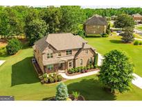 Beautiful two-story brick home with lush landscaping and a well-manicured lawn and traditional architectural details at 2589 Lake Erma Dr, Hampton, GA 30228