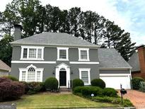 Charming two-story home featuring a well-manicured lawn, elegant gray facade, and attached two car garage at 2308 Littlebrooke Dr, Dunwoody, GA 30338