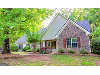 Charming single-Gathering home featuring brick and siding exterior, complemented by lush landscaping and mature trees at 530 Austin Dr, Mcdonough, GA 30252