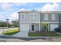 Charming two-story townhome with gray siding, a one-car garage, and a manicured front yard at 109 Feeney Lane, Villa Rica, GA 30180