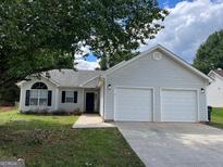 Charming single-story home featuring a two-car garage, tidy landscaping, and a welcoming entrance at 3081 Regal Dr, Mcdonough, GA 30253