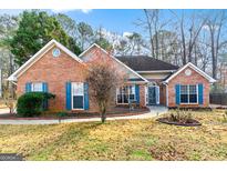 Charming brick home featuring blue shutters, a landscaped front yard, and a welcoming entrance at 418 Crosshaven Way, Mcdonough, GA 30253