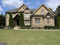 Stunning two-story brick home with manicured lawn and beautiful landscaping, creating an inviting curb appeal at 2220 Cambridge Hill Ct, Dacula, GA 30019