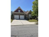 Charming two-story home with a two-car garage and beautifully landscaped front yard on a sunny day at 4230 Vinca Way, Union City, GA 30291