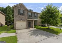 Charming two-story home with a brick and gray siding exterior and attached one car garage at 5768 Grande River Rd, Atlanta, GA 30349