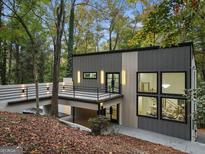 Modern home with gray siding, stylish lighting, balcony, and large windows offering abundant natural light at 1153 Dawn View Nw Ln, Atlanta, GA 30327