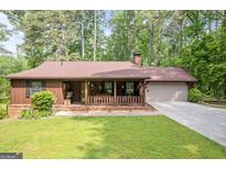 Charming single-story home featuring a welcoming front porch and well-maintained lawn at 6537 Walker Rd, Riverdale, GA 30296