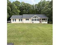 Ranch home featuring a large front yard and covered porch at 60 Carriage Gate Dr, Sharpsburg, GA 30277