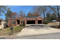Charming brick home featuring a two-car garage and well-maintained lawn at 8828 Patricia Rose, Douglasville, GA 30134