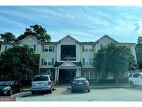 Apartment building with a light exterior, green shutters and trees at 6302 Waldrop Pl, Decatur, GA 30034