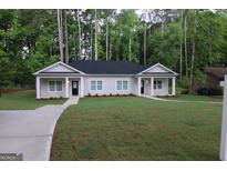 Charming single-story home with a well-manicured lawn and inviting entryway nestled amongst mature trees at 320 Sharon Dr # A & B, Fayetteville, GA 30214