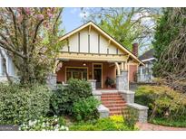 Charming bungalow exterior with brick steps, stone accents, and lush landscaping in a beautiful garden setting at 171 Westminster Ne Dr, Atlanta, GA 30309