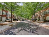 Charming street view of brick townhomes with mature trees lining the street, creating a welcoming atmosphere at 2160 Dillard Xing, Tucker, GA 30084