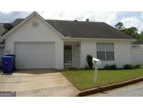 Charming single-story home featuring a one car garage, manicured lawn, and welcoming entrance at 214 Oak Cir, Stockbridge, GA 30281