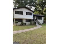 Charming two-story home with white and brown trim and a well-maintained front yard at 554 Windsor Dr, Forest Park, GA 30297