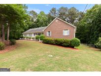 Charming brick and siding home with manicured lawn and mature trees, perfect for Gathering living at 372 River Point Dr, Mcdonough, GA 30252