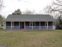 Charming single-story home featuring a covered front porch and a well-maintained lawn at 56-1 N East Main St, Hampton, GA 30228