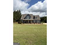 Charming two-story home with blue siding, white trim, a well-manicured lawn and landscaping at 808 Covered Bridge Rd, Covington, GA 30016