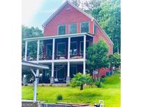 Spacious two-story home with a covered porch, waterfront access, and lush green lawn at 1295 Heritage Dr, Villa Rica, GA 30180