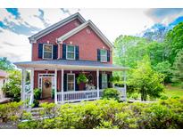 Charming brick two-story home with a welcoming front porch and well-maintained landscaping at 1295 Heritage Dr, Villa Rica, GA 30180