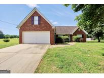 Charming single-Gathering brick home with a two-car garage and a well-manicured lawn at 502 Gallantry Trl, Mcdonough, GA 30252