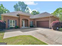 Charming brick home featuring a well-maintained yard, arched entryway, and attached two-car garage at 570 Mcgarity Dr, Mcdonough, GA 30252