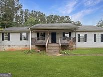 Charming single-story home with a covered porch and a well-maintained lawn at 401 Grove Pointe Ct, Locust Grove, GA 30248