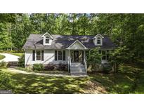 Charming home with stone accents, landscaped yard, and inviting front porch at 3180 Sweetbriar Dr, Villa Rica, GA 30180