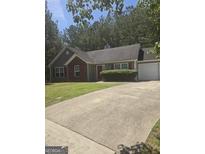 Charming single-Gathering home featuring a well-manicured lawn and a two-car garage at 310 Wolf Creek Cove, South Fulton, GA 30349