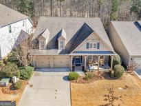 Charming home with a three-car garage, dormers, front porch, and beautiful landscaping at 1141 Pebble Creek Ln, Locust Grove, GA 30248