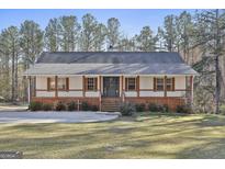 Charming ranch home featuring a welcoming porch, crisp white siding, and a well-manicured lawn at 1234 Coweta Heard Rd, Hogansville, GA 30230