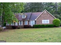 Classic brick house with mature trees and well-kept front yard at 8039 Woods Ln, Jonesboro, GA 30236