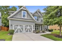 Inviting gray two-story home featuring a two car garage, gray shake siding, and manicured lawn at 70 Pacific Ave, Sharpsburg, GA 30277