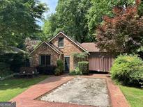 Charming brick home featuring a well-manicured lawn and mature trees in a desirable neighborhood at 725 Brown Pl, Decatur, GA 30030