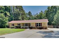 Charming single-story home with a cozy front porch and mature trees at 11953 Brown Bridge Rd, Covington, GA 30016